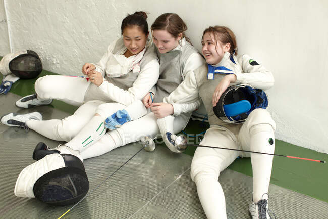 Female fencers sitting together — Stock Photo