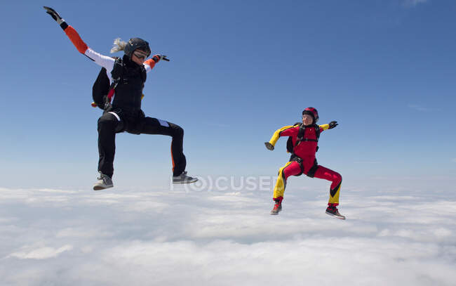 Paracadutismo femminile sopra le nuvole — Foto stock