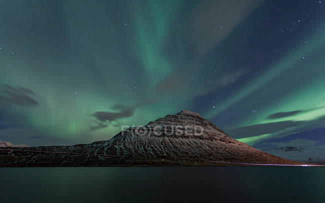 Colina con cielo en auroras boreales - foto de stock
