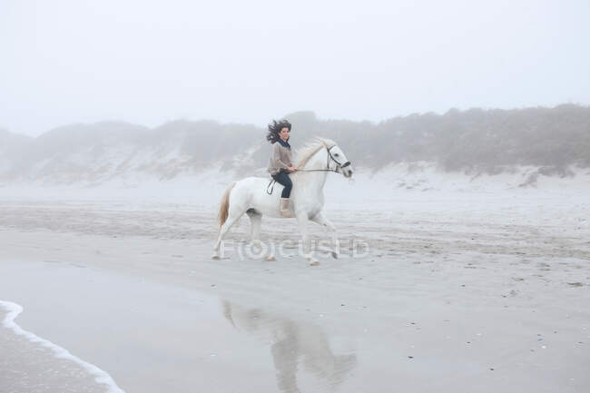 Жінка катається на коні на пляжі — стокове фото