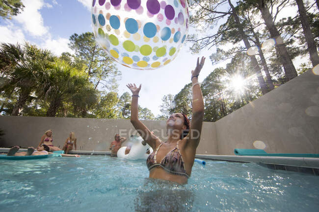 Woman playing throwing beach ball in swimming pool, Santa Rosa Beach, Florida, USA — Stock Photo