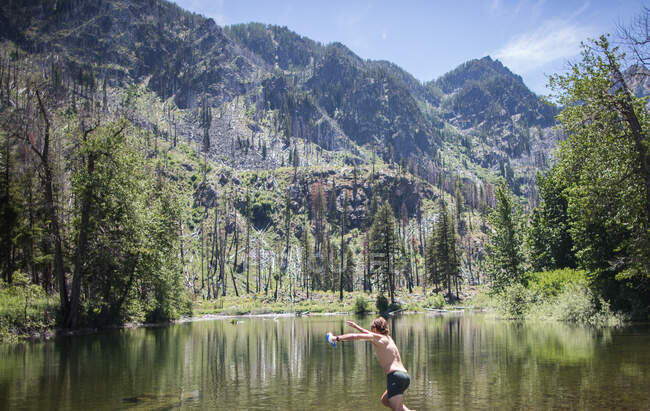 Man jumping into stream, Incantesimi, Laghi alpini Wilderness, Washington, Stati Uniti d'America — Foto stock