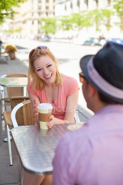 Young couple in sidewalk cafe — Stock Photo