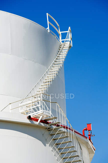 Escaliers sur réservoir de stockage de pétrole avec ciel bleu clair — Photo de stock