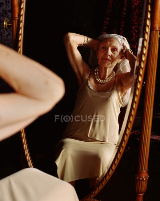Старшая женщина смотрит в зеркало — стоковое фото