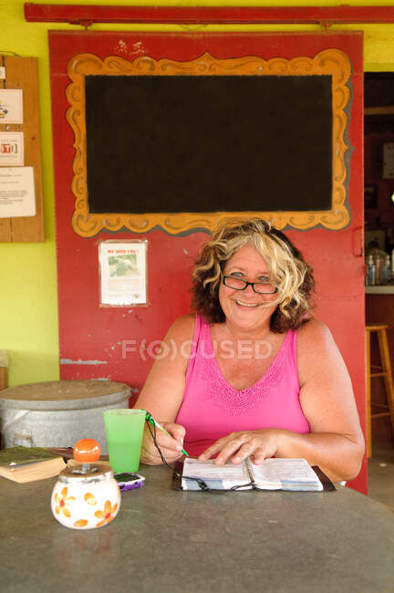 Frau schreibt im Café in Notizbuch — Stockfoto