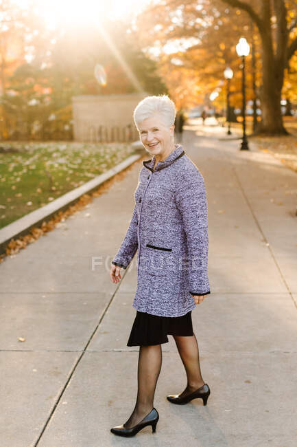 Portrait of senior woman, outdoors, wearing smart clothing — Stock Photo