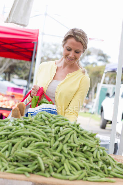 Женщина за покупками на фермерском рынке — стоковое фото