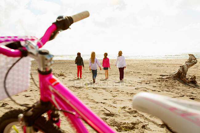 Girls walking over sand at beach — Stock Photo