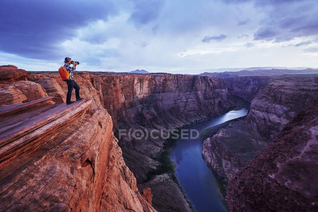 Un photographe prend des photos avec vue sur le fleuve Colorado à Horseshoe Bend, Page, Arizona. — Photo de stock