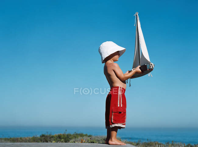 Garçon tenant jouet bateau — Photo de stock