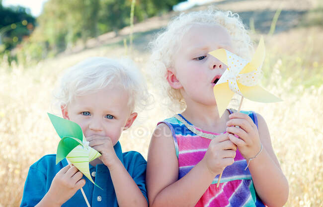 Brother and sister with pinwheels — Stock Photo
