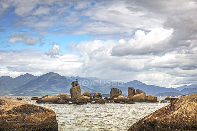 Rocas en el mar por las montañas, Florianopolis, Santa Catarina, Brasil - foto de stock