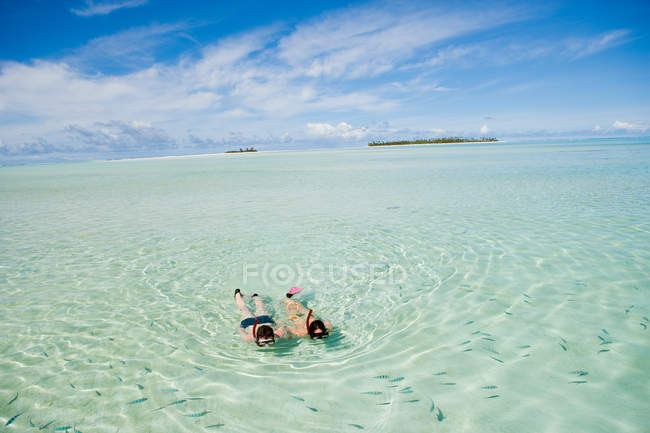 Mid adult couple snorkeling and looking at fish — Stock Photo