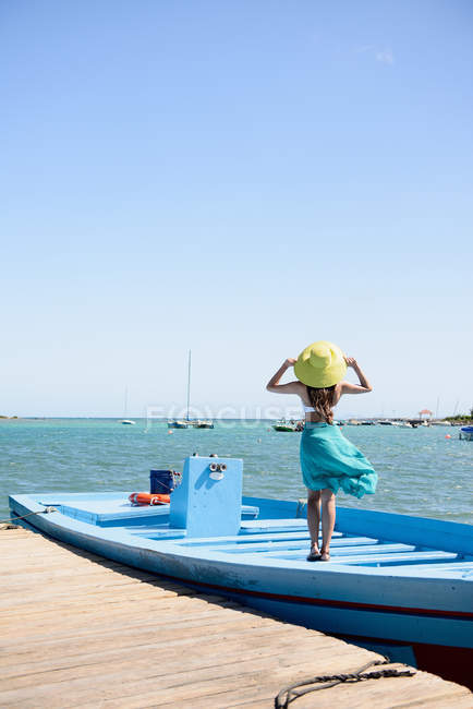 Задний вид женщины, стоящей на лодке в океане — стоковое фото