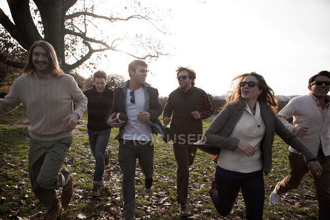 Група друзів, що біжать у парку — стокове фото