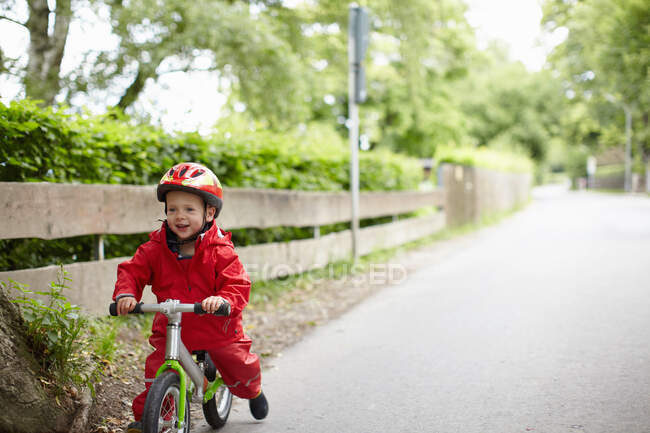 Sourire garçon équitation vélo à l'extérieur — Photo de stock