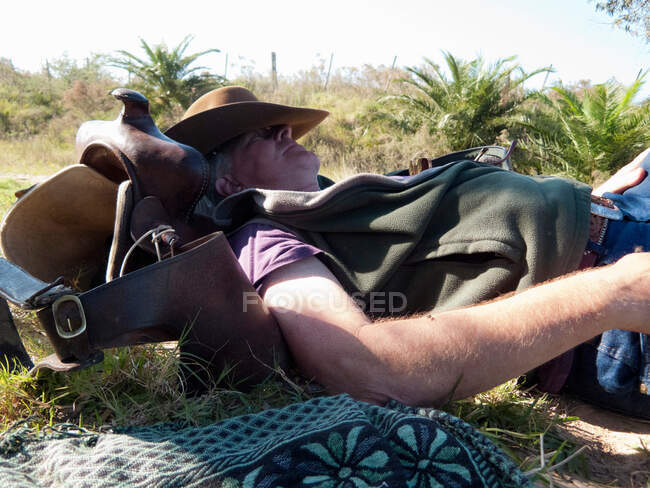 Senior man lying on back resting on saddle, Uruguay — Stock Photo