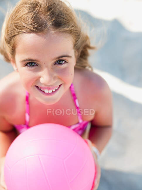 Chica joven con bola sonriendo al espectador - foto de stock
