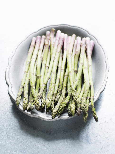 Still life of asparagus bunch in bowl in bright daylight — Stock Photo