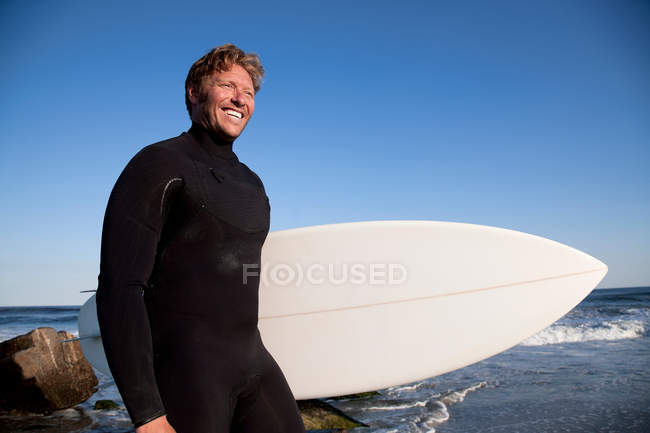 Portrait de surfeur souriant regardant loin sur la plage — Photo de stock