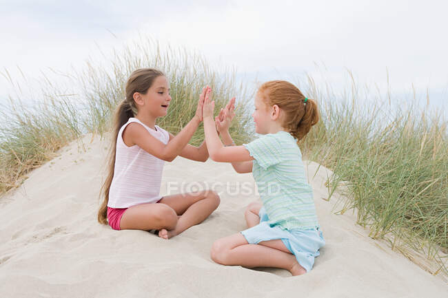 Las niñas jugando palmadita un pastel - foto de stock