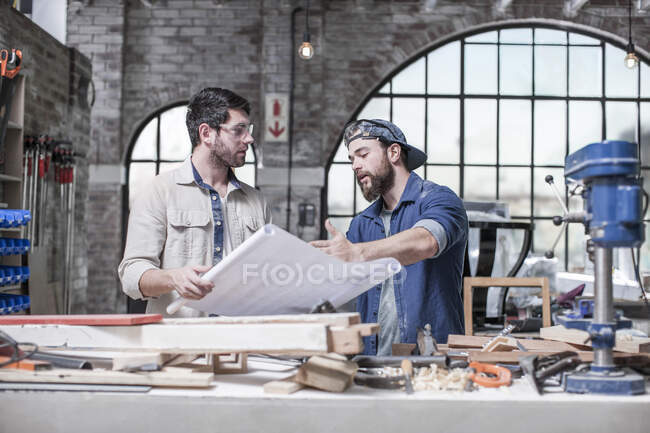 Cape Town, South Africa, Machinist explaining plans to co worker — Stock Photo