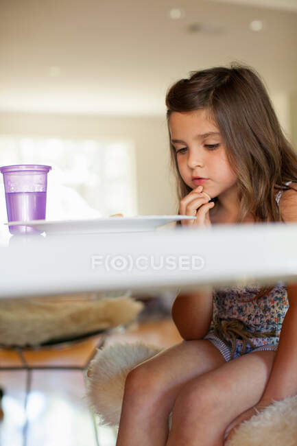 Small girl reading at table — Stock Photo