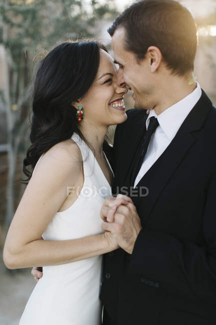 Mariée et marié, face à face, tenant la main, souriant — Photo de stock