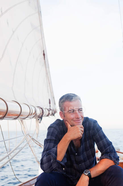 Uomo su una barca a vela sorridente — Foto stock