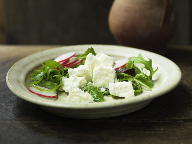Греческий сыр фета в салате с нарезанной редиской и ракетой — стоковое фото