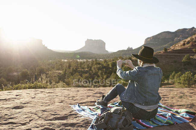Donna seduta su una coperta nel deserto, vista fotografica con smartphone, Sedona, Arizona, USA — Foto stock