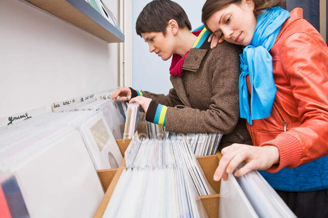 Una pareja lesbiana mirando registros - foto de stock