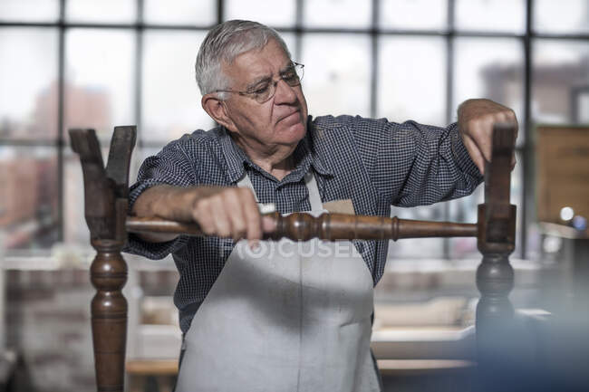 Cape Town, South Africa, elderly craftsman working on bench in workshop — Stock Photo