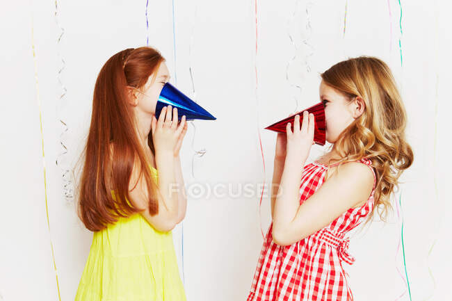 Chicas jugando con sombreros de fiesta - foto de stock