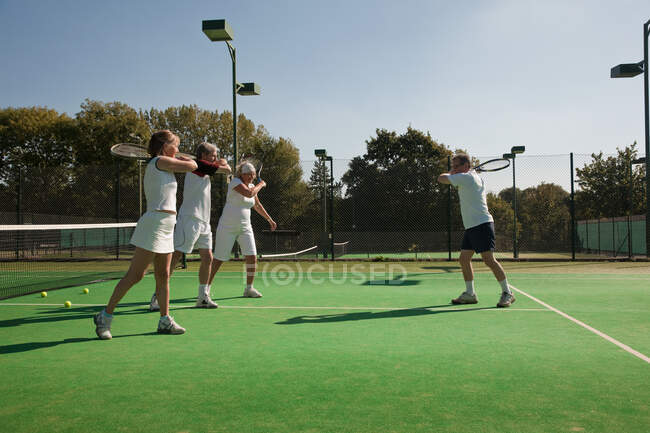 Ältere und ältere Erwachsene üben Tennis — Stockfoto