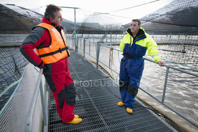 Workers at salmon farm in rural lake — Stock Photo