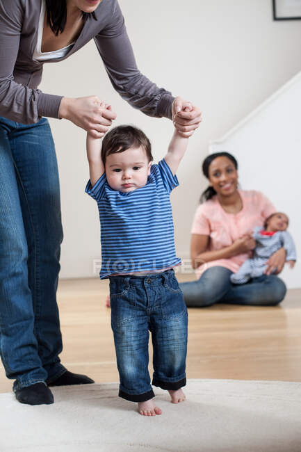 Mother helping baby son to walk — Stock Photo
