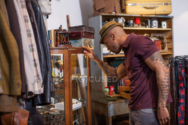Молодий чоловік дивиться в кабінет у вінтажному магазині — стокове фото