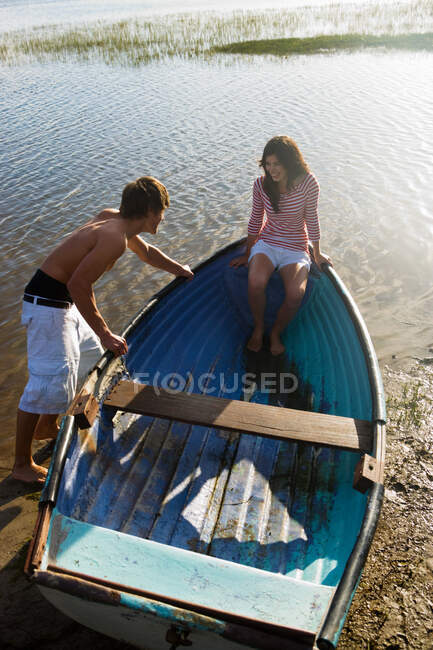 Teenage couple with rowboat — Stock Photo