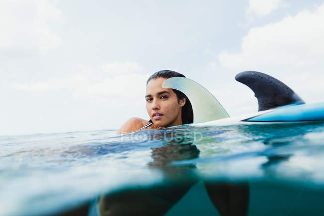 Nivel de superficie de la mujer en la tabla de surf mirando a la cámara, Oahu, Hawaii, EE.UU. - foto de stock