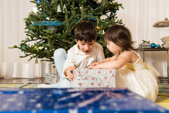 Children opening Christmas gifts — Stock Photo
