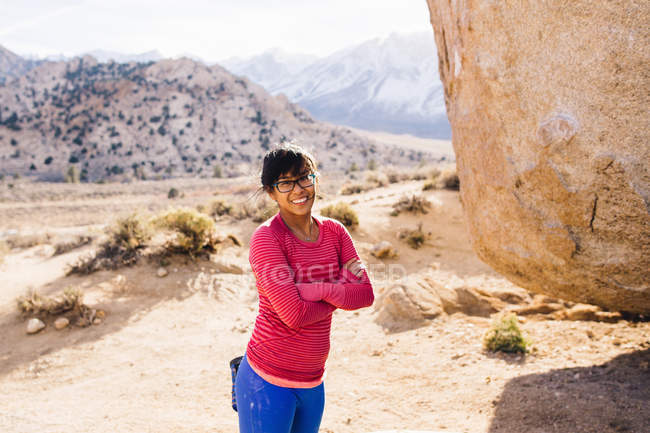 Donna, braccia incrociate guardando la macchina fotografica sorridente, Buttermilk Boulders, Bishop, California, USA — Foto stock