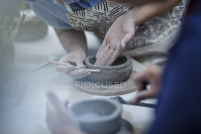 Ciudad del Cabo, Sudáfrica, dos hembras moldeando arcilla en taller de cerámica - foto de stock