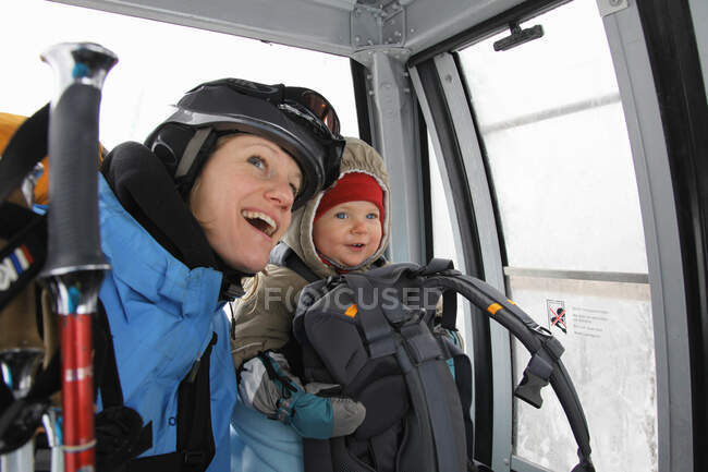 Mother and child riding ski lift — Stock Photo