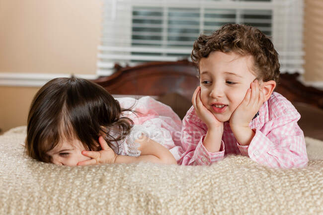 Дети, лежащие на кровати — стоковое фото