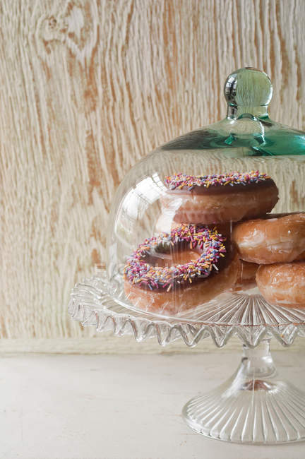 Doughnuts under glass jar — Stock Photo