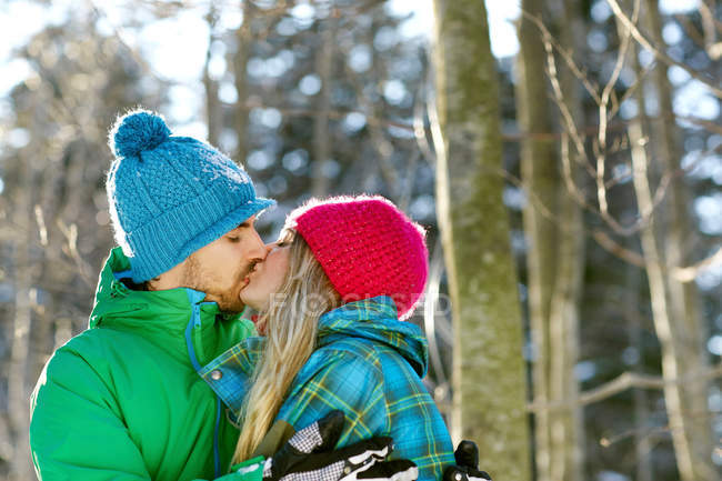 Couple portant des chapeaux en tricot, embrasser — Photo de stock