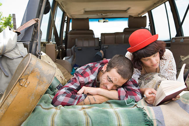 Paar liegt im Rücken eines Geländewagens — Stockfoto