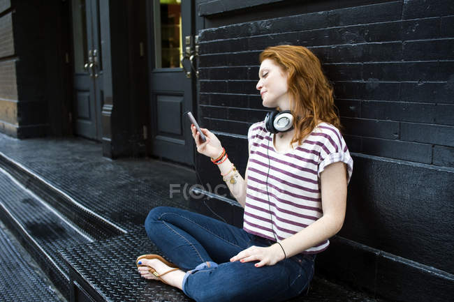 Портрет молодой женщины с помощью мобильного телефона — стоковое фото